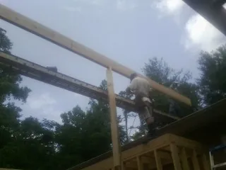 Carpenter setting a ridge beam over a new addition frame — Ice Dam Removal by Roofing Brothers in Waynesfield