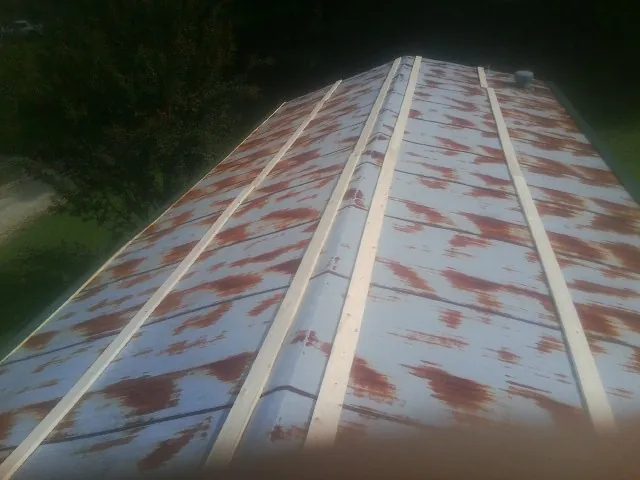 Rusted metal roof panels with new wood purlins before replacement — Storm Damage Roof Repair in Waynesfield by Roofing Brothers